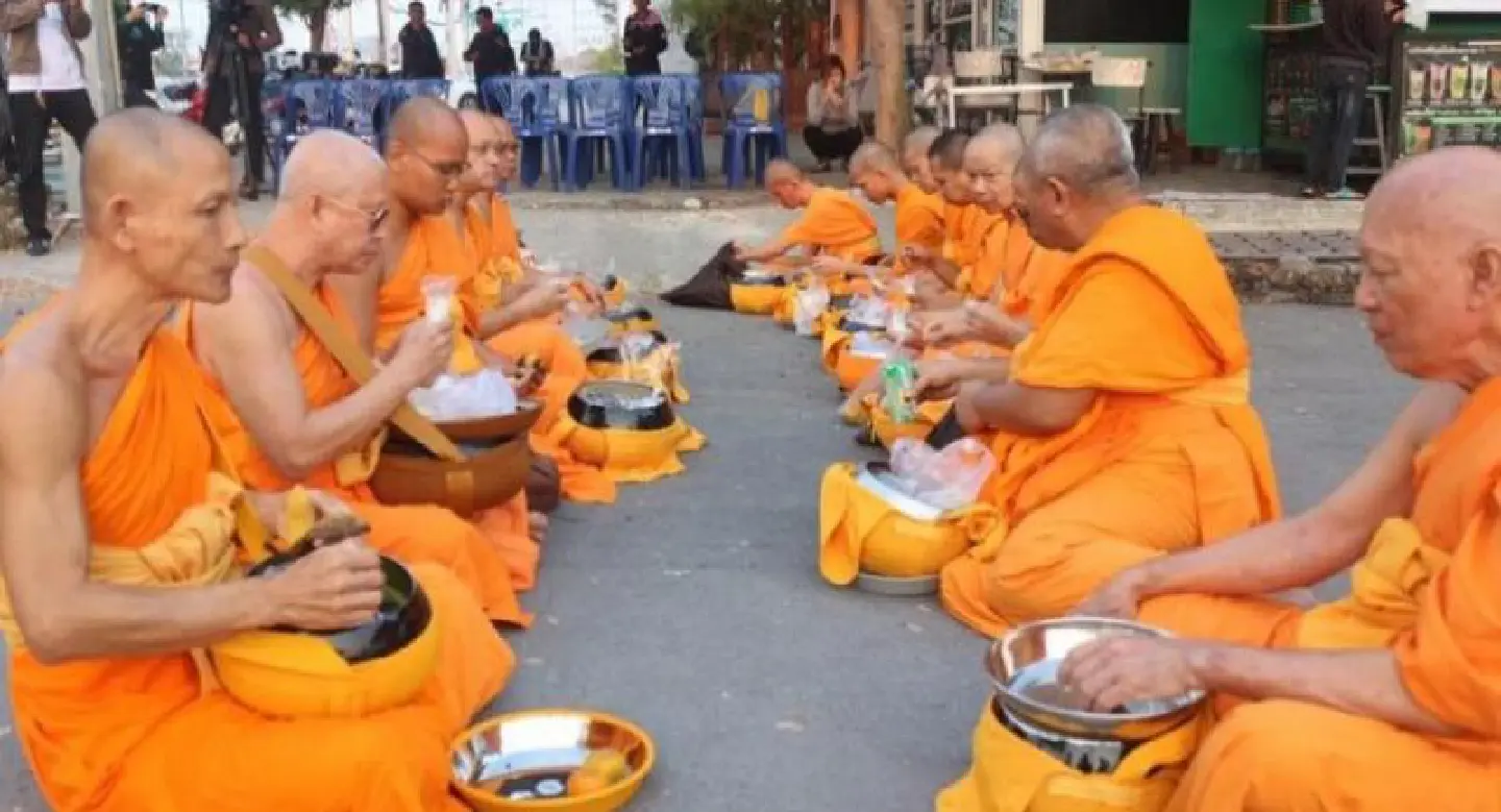Dhammakaya monks eat in street after being ordered to use designated gate Dhammakaya monks eat in street after being ordered to use designated gate
