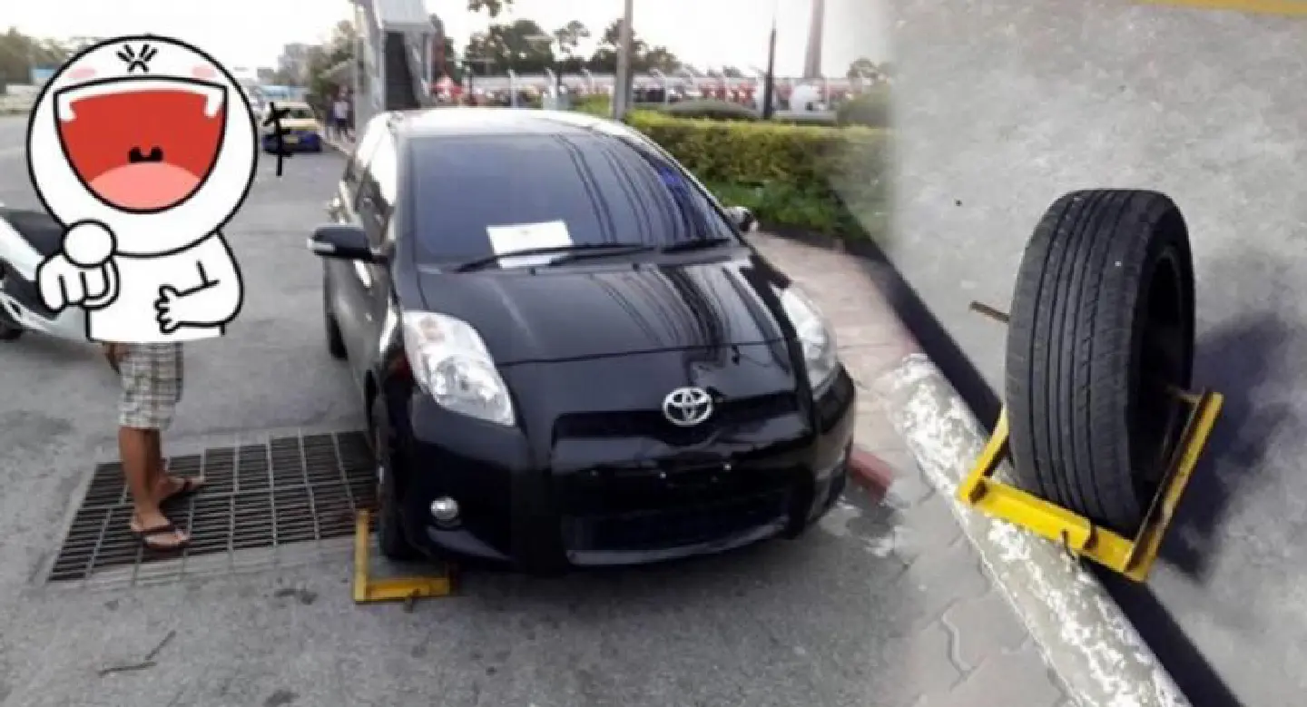 Driver baffles passersby by changing tyre caught in wheel clamp, but still pays fine
