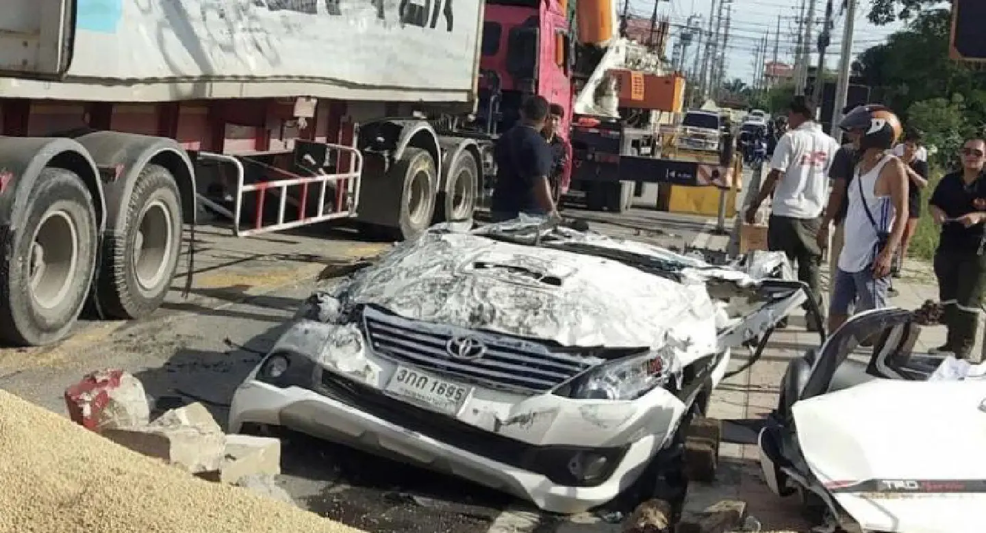 Driver cut free after truck carrying soybeans tips over on to his car Driver cut free after truck carrying soybeans tips over on to his car