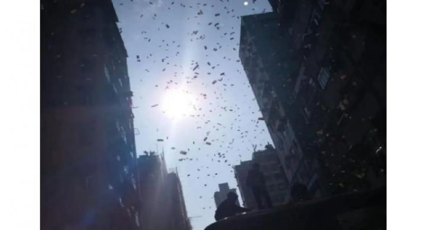 Money falls from sky onto busy Hong Kong street