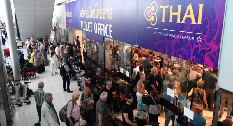Stranded passengers wait the Thai Airways ticket counter at the Suvarnabhumi International Airport in Bangkok on February 28, 2019. // AFP PHOTO