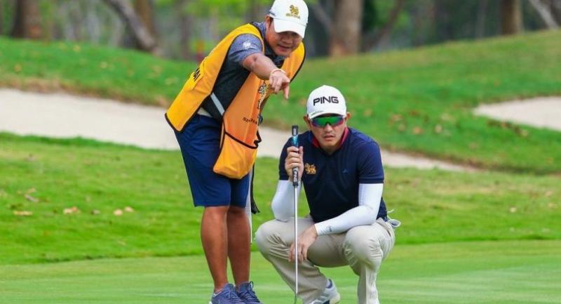 Sattaya Supupramai, right, listens to advice from his caddie.