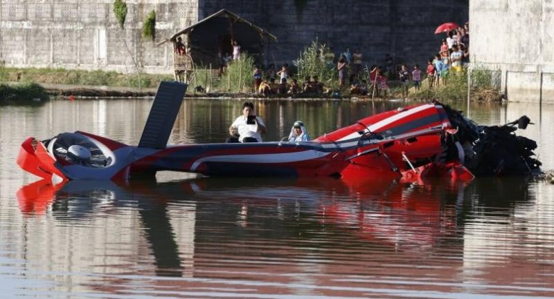 A Filipino on a raft documents the wreckage of a helicopter that crashed in a pond in Malolos City, Bulacan Province, north of Manila, Philippines 25 April.//EPA-EFE