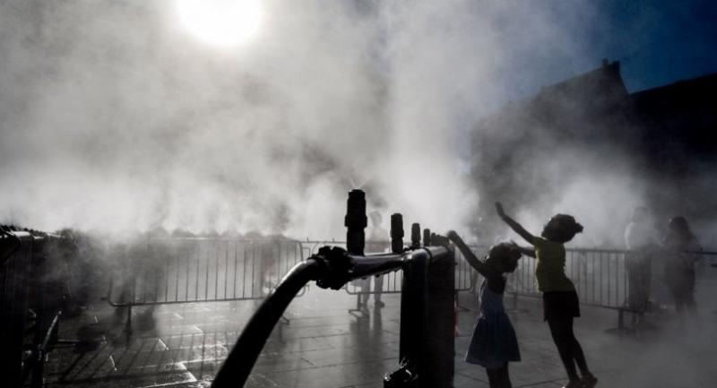 Children play next to a water atomizer on a central square in Strasbourg, eastern France on June 28, 2019./AFP
