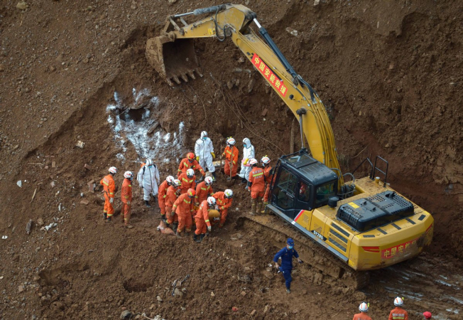 Rescuers transport victims found dead in a landslide in Pingdi village, Shuicheng county of Guizhou province, on Friday. All personnel are racing against the clock for hopeful survivors. Photo provided to China Daily