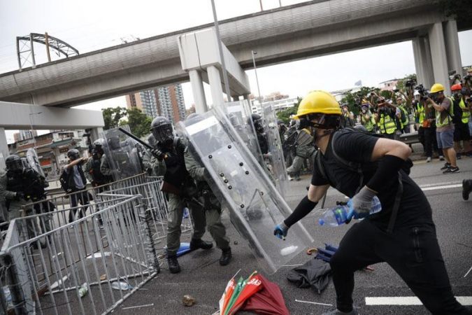 A protester (right) tries to attack riot police with an iron pole during an unauthorized assembly in Yuen Long, Hong Kong, July 27, 2019. (PHOTO / CHINA DAILY)