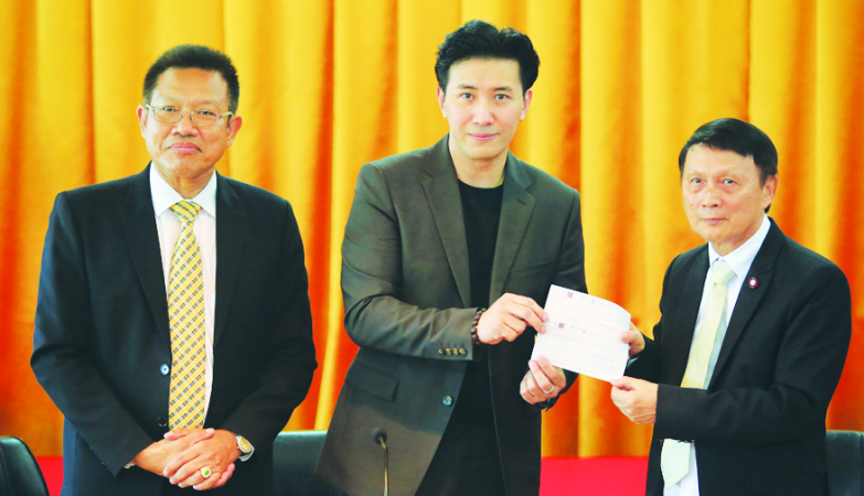 Acting on behalf of an underage driver's family, TV news presenter and actor Kanchai “Noom” Kamnerdploi (centre) presents the compensation cheques for the deceased and wounded victims to Civil Court chief judge Opas Anantasomboon (right) on Tuesday. Nation/Rachanon Intharaksa