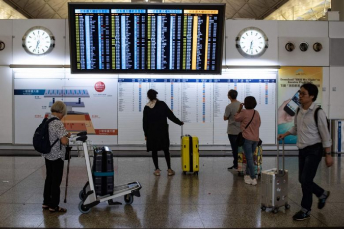 Passengers checking the status of their flights on an electronic board at Hong Kong's international airport, on Aug 14, 2019, following two days of protests. (Photo: AFP)