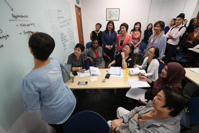 Senior Parliamentary Secretary for Manpower and Education Low Yen Ling (in pink blazer) observing a LifeWork course for mature workers with Centre for Seniors executive director Lim Sia Hoe (in pale grey, standing).ST PHOTO: TIMOTHY DAVID