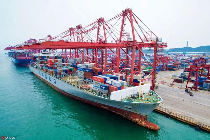 Containers are off-loaded from a cargo ship at Qingdao Port in East China's Shandong province. (Photo / IC)