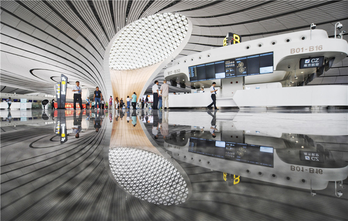 Staff members and people posing as passengers walk in the terminal of Beijing Daxing International Airport on July 19 during a test of the airport's operations. The airport will open on Sept 30. TAO RAN/FOR CHINA DAIL