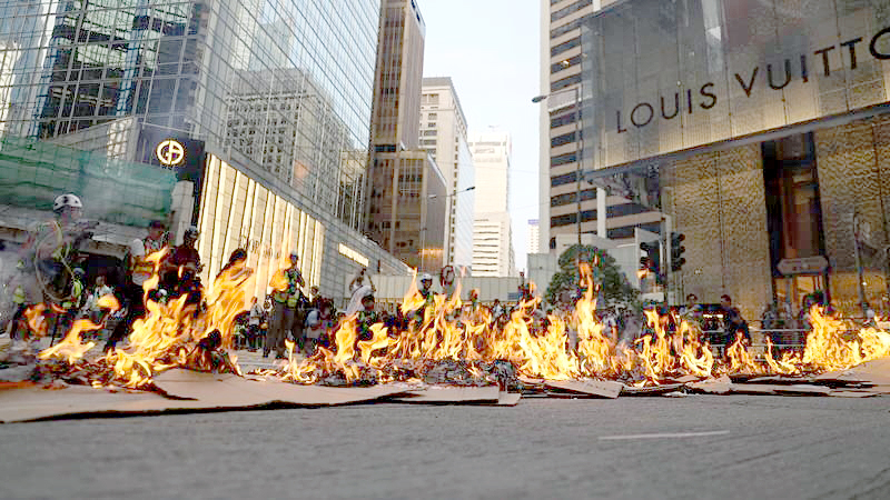 Fires set by protesters block the road in Central on Sunday. (PHOTO / CHINA DAILY)