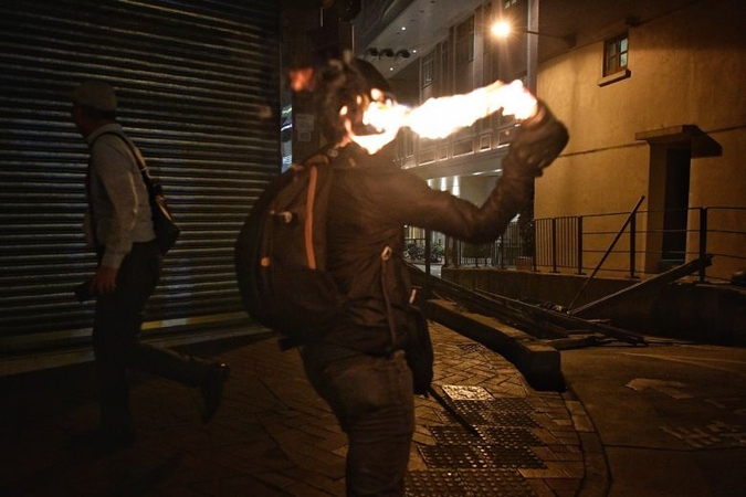 A protester throws a petrol bomb to light up a makeshift blockade in Hong Kong's Wan Chai district on Oct 4, 2019.ST PHOTO: CHONG JUN LIANG