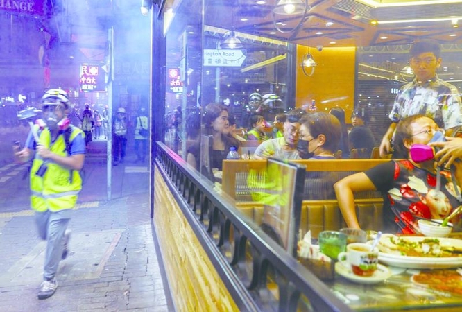 Diners in a Causeway Bay restaurant become upset as tear gas seeped into the diner on Friday night. Rioters took to the steets again after the government announced ban on mask-wearing at public assemblies. 