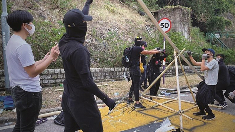 Radical students at the Chinese University of Hong Kong construct a giant catapult to fire bricks and gasoline bomb on Wednesday. (PHOTO / CHINA DAILY)