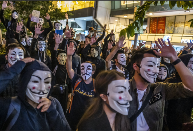 Demonstrators wearing anonymous masks known as Guy Fawkes masks raise their hands during a protest at Urban Council Centenary Garden in Hong Kong on Nov. 5, 2019.  CREDIT: Bloomberg photo by Justin Chin
Photo by: Justin Chin — Bloomberg
