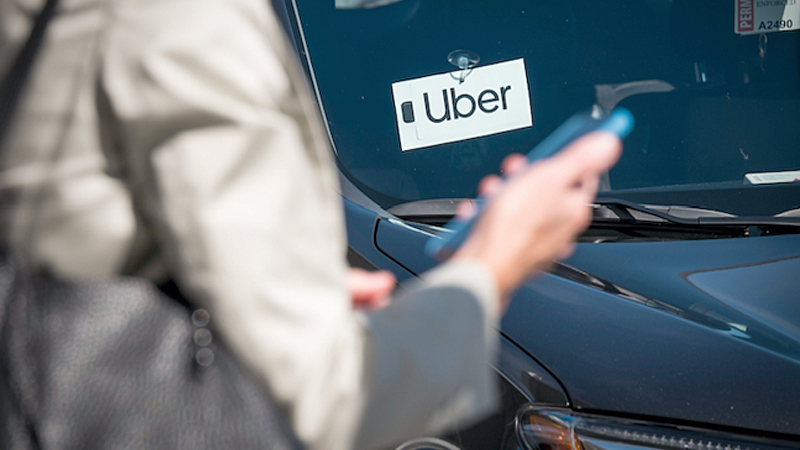 A traveler uses a smartphone while waiting for ride. MUST CREDIT: Bloomberg photo by David Paul Morris