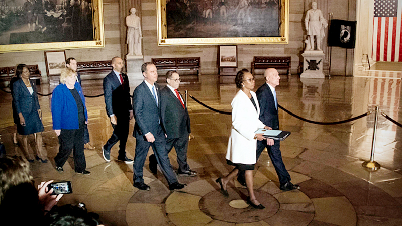 The House sergeant at arms, right, and clerk lead impeachment managers, including Reps. Adam Schiff, center left, and Jerrold Nadler, center right, through the Capitol Rotunda on Wednesday to deliver two articles of impeachment against President Trump to the Senate. MUST CREDIT: Washington Post photo by Melina Mara
