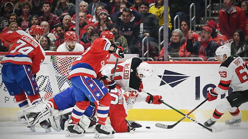 Capitals goaltender Ilya Samsonov (30) makes a save as Devils forward Michael McLeod lands on him during the second period of Thursday night's game between Washington and New Jersey. MUST CREDIT: Washington Post photo by Toni L. Sandys