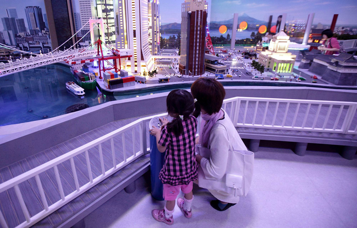 A child and her mother look at a diorama of Tokyo at night made with Lego toy bricks at the Lego Land Discovery Center Tokyo on June 14, 2012. MUST CREDIT: Bloomberg photo by Tomohiro Ohsumi.