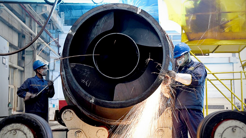 Employees work on the production line of a heavy machinery manufacturing plant in Zhangjiakou, Hebei province. [Photo by Chen Xiaodong/For China Daily]
