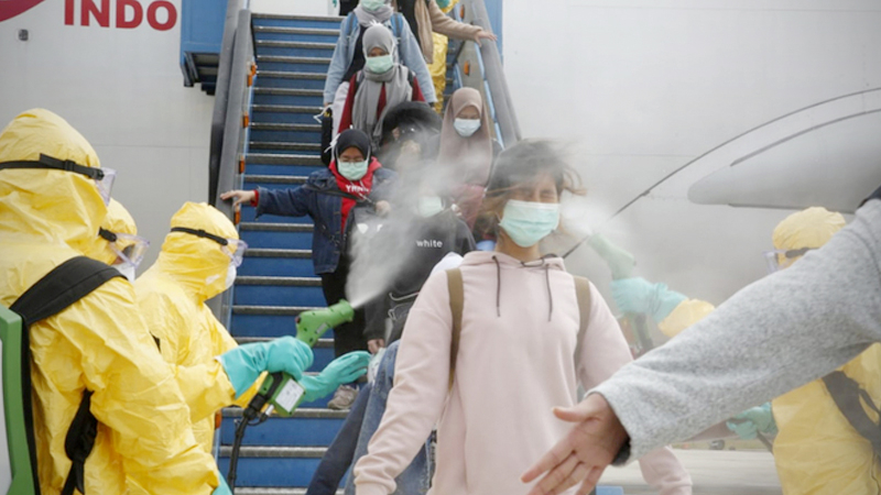 Medical officers spray disinfectant liquid on Indonesian citizens coming from Wuhan, China upon arrival at Hang Nadim Airport, Batam, Riau Islands, on Feb. 2. A total of 238 Indonesian citizens who had been in Wuhan, China were subsequently transferred to Natuna to undergo observation for approximately two weeks to ensure they were healthy and free from the coronavirus. (Antara/Handout Ministry of Foreign Affairs)