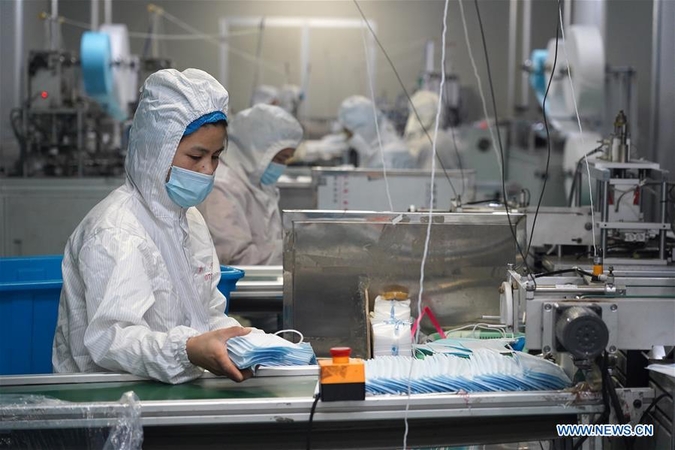 Workers make protective masks at the workshop of a company in Jinxian county, East China's Jiangxi province, Feb 1, 2020. To help fight the outbreak of pneumonia caused by novel coronavirus, workers of many medical material companies rushed to work ahead of schedule to make protective equipment. [Photo/Xinhua]
