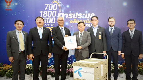 Dtac CEO Sharad Mehrotra, third left, accompanied by his management team, submits the bid documents for the upcoming multiband spectrum auction to NBTC's secretary-general Takorn Tanthasit.