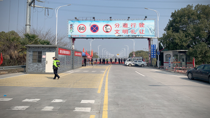 Police guard a barricaded bridge from virus-stricken Hubei Province, which is under quarantine. A loudspeaker warns Hubei residents and vehicles that they may not enter. MUST CREDIT: Washington Post photo by Gerry Shih