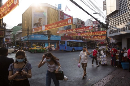 Pedestrians wearing face masks walk along Yoawarat Road in Bangkok, Thailand, on Feb. 5, 2020. MUST CREDIT: Bloomberg photo by Andre Malerba.