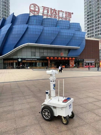 A robot, capable of checking the body temperature of people five meters away, works outside a shopping mall in Guangzhou, Guangdong province to help fight the novel coronavirus. [Photo provided to chinadaily.com.cn]