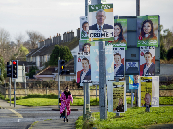 A pedestrian passes by general election posters for various political parties in Dublin on Feb. 6, 2020. MUST CREDIT: Bloomberg photo by Aidan Crawley.
