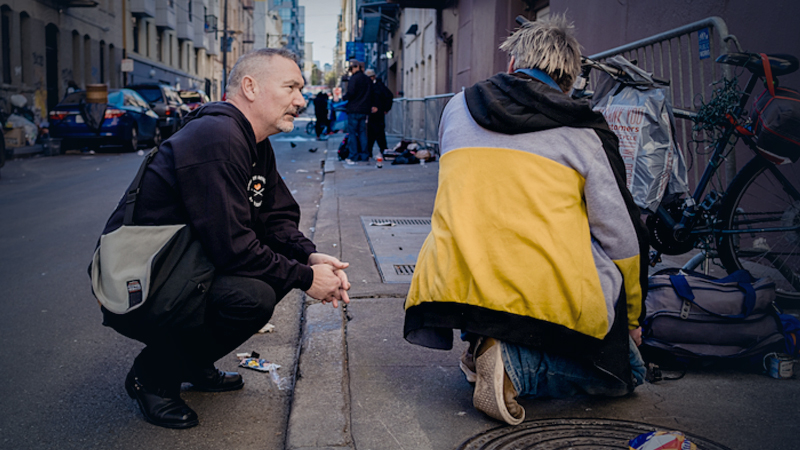 Paul Harkin, director of harm reduction at GLIDE, hands out naloxone, fentanyl detection packets and tinfoil in an alleyway in San Francisco's Tenderloin neighborhood. MUST CREDIT: Photo by Nick Otto for The Washington Post.