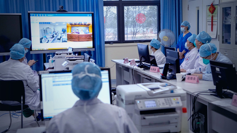 Doctors exchange experiences of treating novel coronavirus pneumonia cases during a video conference at the West Wing of Wuhan Union Hospital in Wuhan, Hubei province, on Feb 11. [Photo by Tang Mingming/For China Daily]