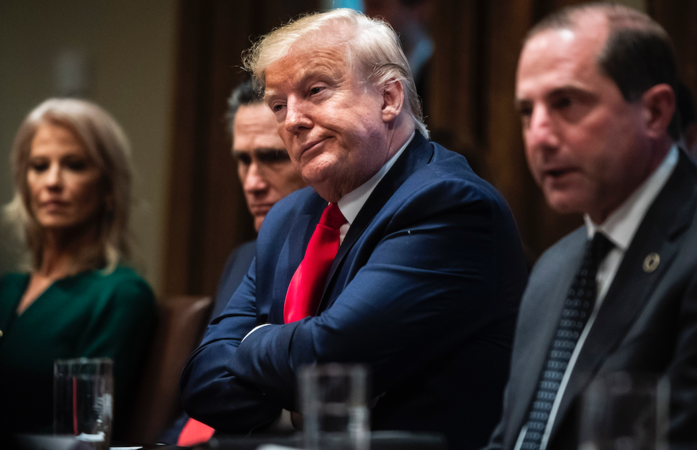 President Trump, flanked by Sen. Mitt Romney, R-Utah, and Secretary of Health and Human Services Alex Azar, in the Cabinet Room at the White House in Washington on Nov 22, 2019. MUSTS CREDIT: Washington Post photo by Jabin Botsford.
