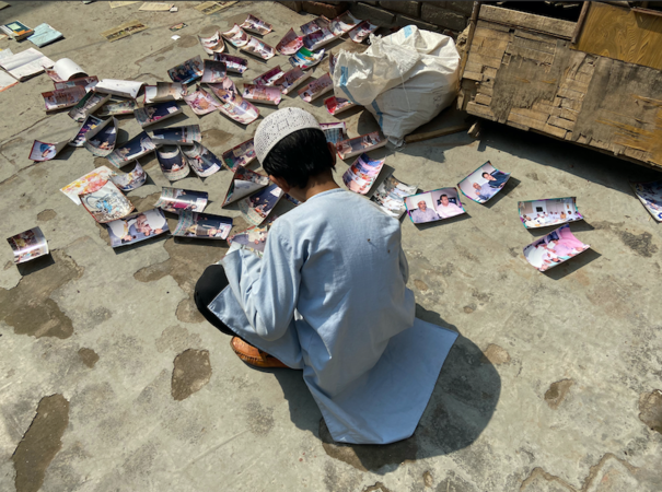 A child looks through photographs of Saleem Kassar's family salvaged from their torched home in Delhi. MUST CREDIT: Washington Post photo by Niha Masih