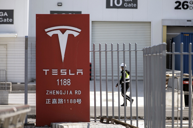 A worker walks past gates at the Tesla gigafactory in Shanghai on Feb. 17, 2020. MUST CREDIT: Bloomberg photo by Qilai Shen.

