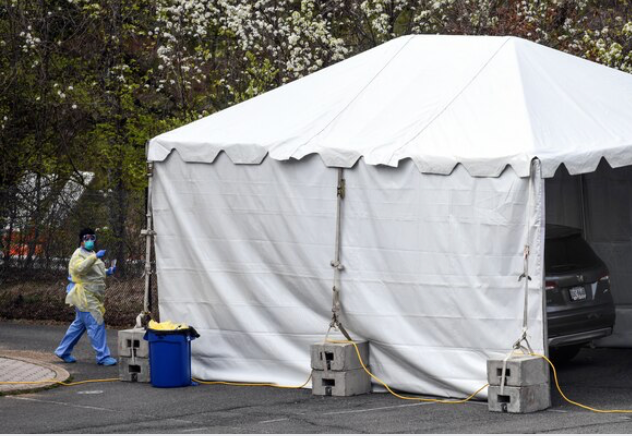 A health-care worker prepares to administer a test at the temporary drive-through covid-19 sample collection site in the Washington suburb of Arlington, Virginia, on March 18, 2020. MUST CREDIT: Washington Post photo by Toni L. Sandys