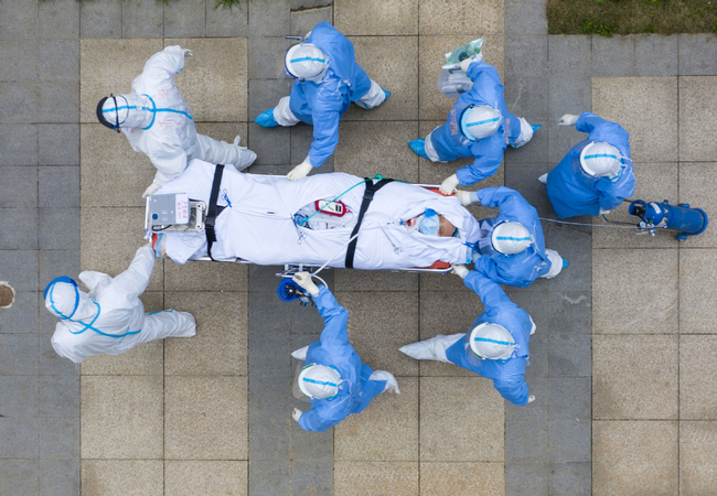 Medical workers take a novel coronavirus patient for a CT scan at the Tongji Hospital affiliated to Huazhong University of Science and Technology's Zhongfa Xincheng branch in Wuhan, Hubei province, on March 6. CAI YANG/FOR CHINA DAILY