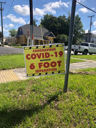 Signs encouraging social distancing are scattered around downtown Live Oak in Suwannee County, Fla. Many residents of the rural county are reluctant to embrace a return to normal. MUST CREDIT: Washington Post photo by Lori Rozsa