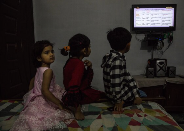 Ahmed (right), 10, with his sister Zari, 8, and cousin Sana, 5, watch English classes on the Pakistan Television network program called teleschool on May 11, 2020. Schools in Pakistan have been closed since March 17 and won't reopen until at least July 15, 2020. MUST CREDIT: Photo by Sarah Caron for The Washington Post.