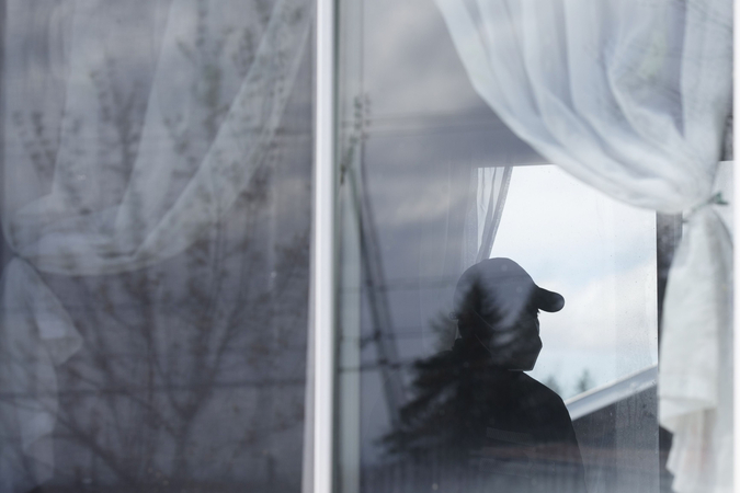 A migrant worker wearing a protective mask stands inside a trailer while starting a 14-day quarantine at a farm in Quebec on May 8, 2020. MUST CREDIT: Bloomberg photo by Christinne Muschi
