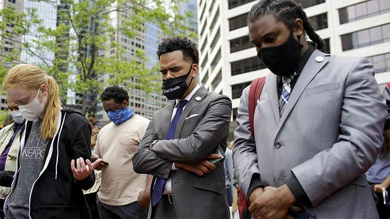 Protesters pray outside the Hennepin County Government Center in Minneapolis. Demonstrations took place across the country this week after the death of George Floyd, a black man who had been pinned to the ground by a police officer kneeling on his neck. MUST CREDIT: Photo by Joshua Lott for The Washington Post