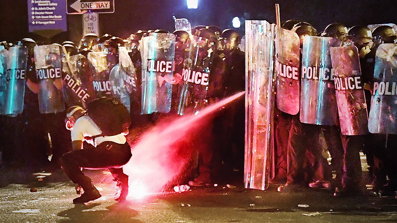A protester went to retrieve a flare that had been tossed at police and was immediately doused with tear gas in a park across the street from the White House early Sunday. MUST CREDIT: Washington Post photo by Michael S. Williamson
