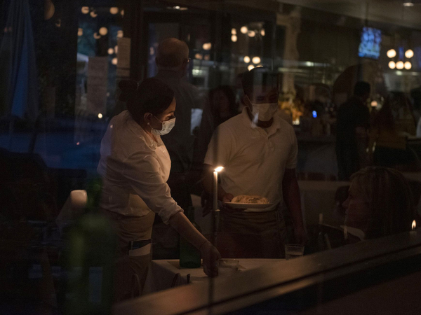 Waiters deliver food to a table at a restaurant after coronavirus disease restrictions were lifted in Houston on May 27., 2020. MUST CREDIT: Bloomberg photo by Callaghan O'Hare.