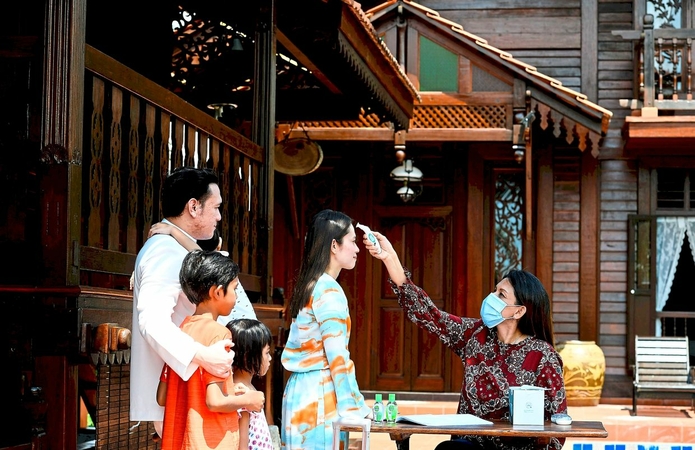 Trial run: Norhanom Mohd Anuar (right), an employee at Pondok Azzmo Guesthouse in Puchong, taking the temperature of a ‘guest’ in a mock exercise as they prepare to reopen.