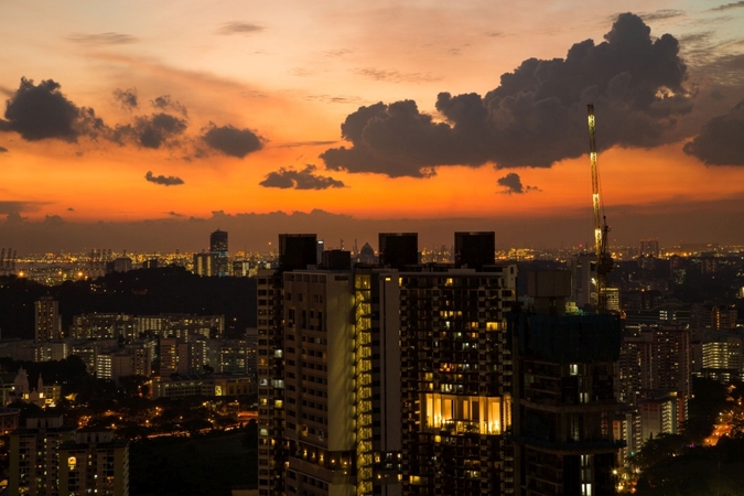 Residential buildings are illuminated at dusk in Singapore, on Sept. 15, 2016. MUST CREDIT: Bloomberg photo by SeongJoon Cho.