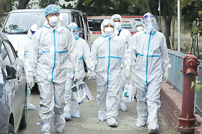 Doctors clad in PPEs enter the Covid-19 unit at Dhaka Medical College Hospital. Despite fears of infection, they have been treating patients for around two months, staying at a city hospital far from home. The photo was taken recently. Photo: Amran Hossain