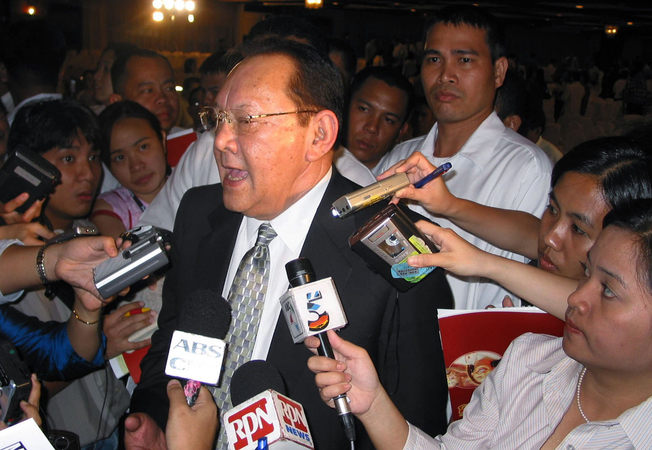 Eduardo Cojuangco speaks to reporters after being re-elected as chairman of San Miguel, the Philippines' largest food and beverage business empirem in Manila on April 20, 2004. MUST CREDIT: Bloomberg photo by Jose Reinares

