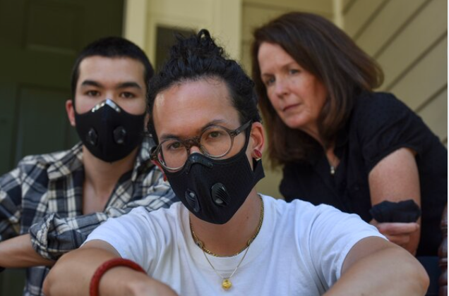 Charlie Mai, 24, center, and Henry Mai, 22, left, pose with their mother, Mary Mai, at their home in Arlington, Va. Their father threatened to leave during an argument over the George Floyd protests. MUST CREDIT: Washington Post photo by Jahi Chikwendiu
